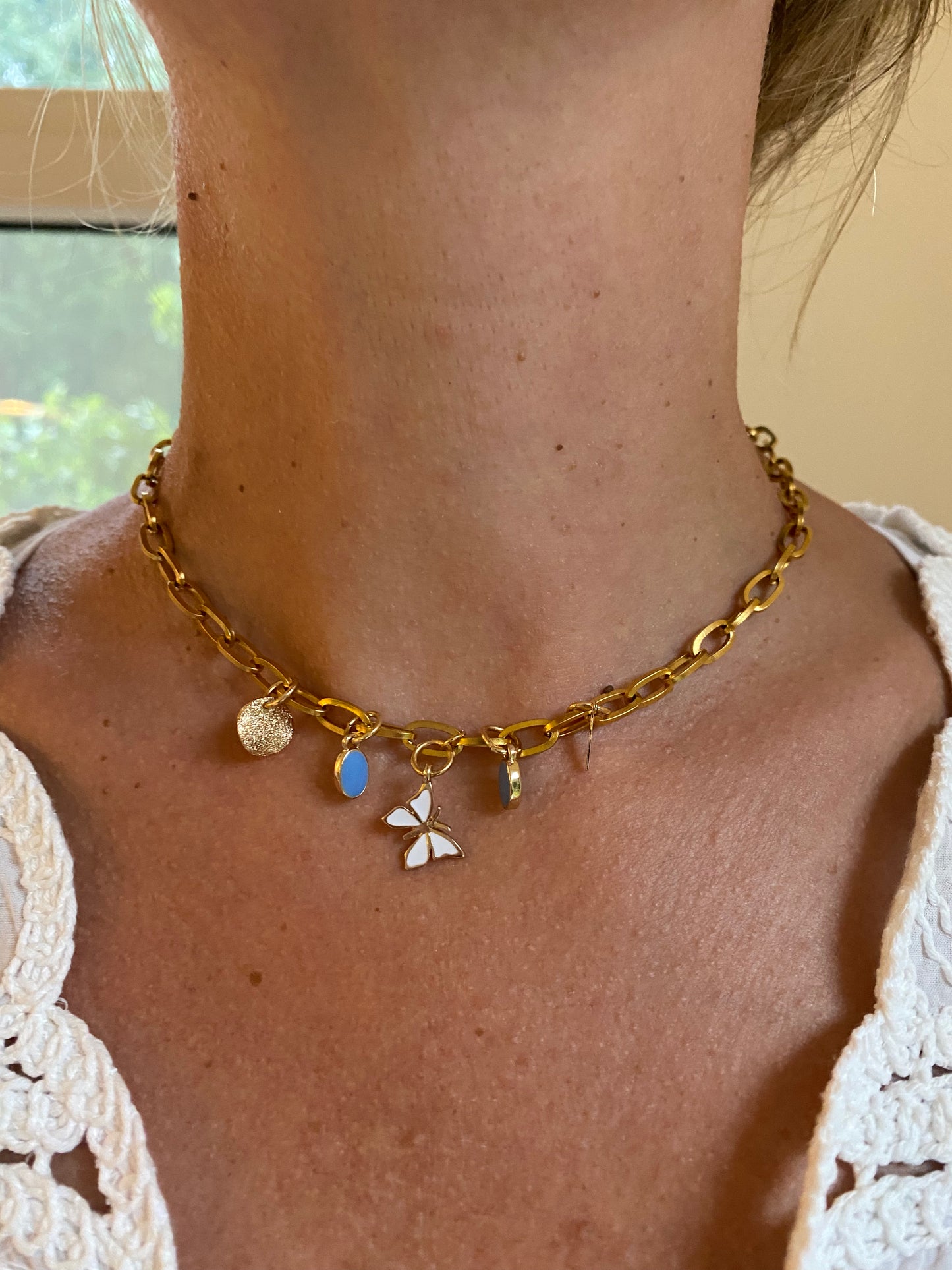 ovale schakelketting met witte vlinder vier bedels